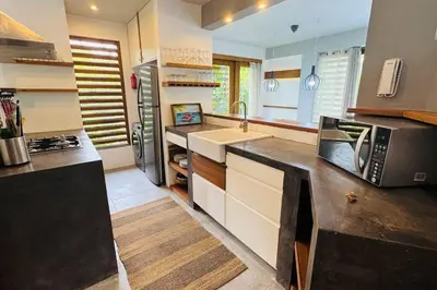 a large kitchen with a sink and a microwave at Private Garden Villa With Parking in Las Terrenas