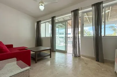 a living room with a red couch and a table at La Fenice Beachfront 3 Bedroom With Parking in Las Terrenas