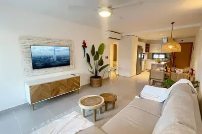 a living room with a couch and a tv on a wall at Tropical Caribbean space with 2 bedrooms C3 in Punta Cana