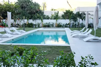 a swimming pool with lounge chairs next to a resort at Tropical Caribbean space with 2 bedrooms C3 in Punta Cana