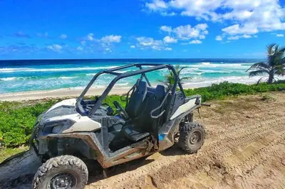 an atv parked on a sandy beach near the ocean at beautiful beachfront complex with 2 pools, free wifi, free beach chairs in Punta Cana