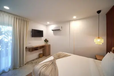 a hotel room with a bed and a television at Empyrean Tropical Wellness Portillo in Las Terrenas
