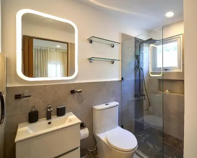 a bathroom with a toilet and a sink and a mirror at Empyrean Tropical Wellness Portillo in Las Terrenas