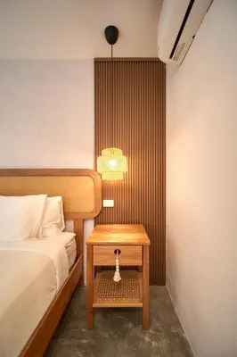a bedroom with a bed and a table with a lamp at Empyrean Tropical Wellness Portillo in Las Terrenas