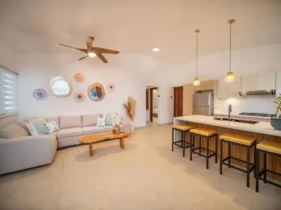 a living room and kitchen with a couch and a table at Green Palace - 7br Luxury Villa in Sosua 3mins from strip plus 24hr security in Sosúa
