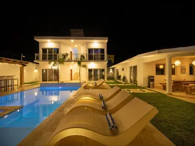 a villa with a swimming pool at night at Green Palace - 7br Luxury Villa in Sosua 3mins from strip plus 24hr security in Sosúa