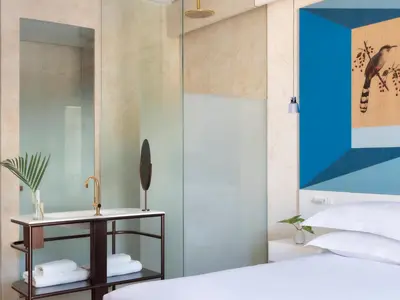 a bedroom with a bed and a table with a mirror at Kimpton Las Mercedes by IHG in Santo Domingo