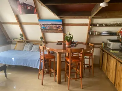 a room with a table and chairs and a bed at Canada House Queen bed in 2nd floor dbl sofa bed in 1st floor BBQ Private pool, river in Jarabacoa