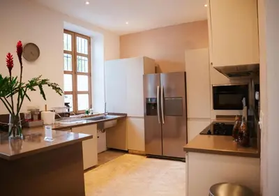 a kitchen with a stainless steel refrigerator and a sink at Billini Hotel, Historic Luxury in Santo Domingo