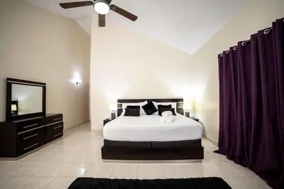 a bedroom with a bed and a ceiling fan at Luxe Comfort 8 Bedroom Villa with Private Pool & Entertainment in Sosúa