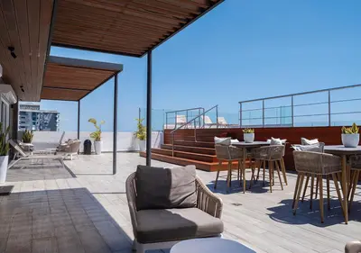 a patio with tables and chairs on a roof at Torre Opus 31 - Apto.605 in Santo Domingo
