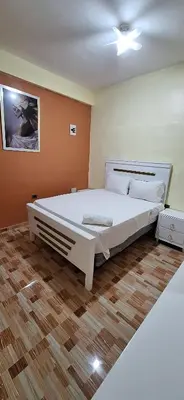 a bedroom with a large white bed and a wooden floor at Hotel Villa Marchena in Azua de Compostela