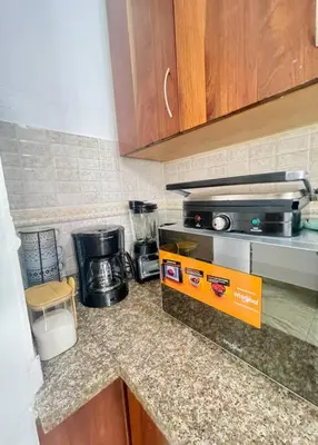 a kitchen with a counter top with a stove top oven at Super Cozy n´Confortable apart. in Ensanche Los Minas