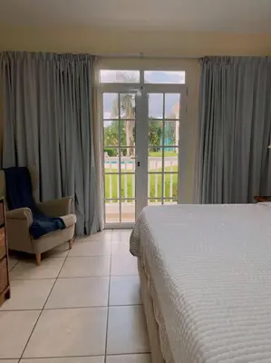 a bedroom with a bed and a chair and a window at Acogedor Apartamento remodelado in Sosúa