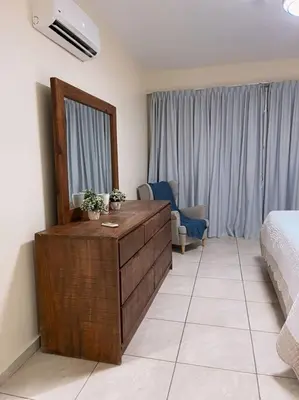 a bedroom with a dresser and a bed and a mirror at Acogedor Apartamento remodelado in Sosúa