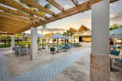 an outdoor patio with tables and chairs and umbrellas at Viva Miches by Wyndham, a Trademark All Inclusive Resort in Miches