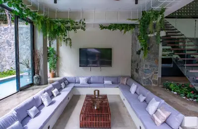 a living room with a large couch and a tv at Casa Ataraxia Modern Luxe Villa in Las Terrenas