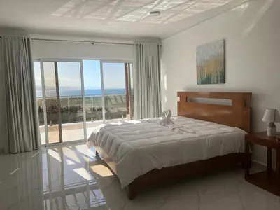 a bedroom with a bed and a large window at Luxury Beach Front Villa with Private pool and stunning Ocean View! in Punta Rucia