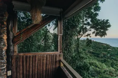 a window of a cabin with a view of the ocean at Casa El Paraiso, Eco Lodge in Santa Bárbara de Samaná