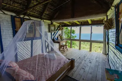 a bedroom with a bed with a mosquito net at Casa El Paraiso, Eco Lodge in Santa Bárbara de Samaná