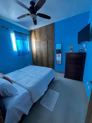 a blue bedroom with a bed and a ceiling fan at Bello Apartamento en Santiago con todas las comodidades in Santiago de los Caballeros