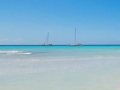 two sailboats in the water on a beach at Caraibidamari in Bayahibe