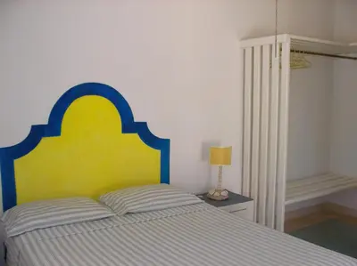a bedroom with a bed with a blue and yellow headboard at Caraibidamari in Bayahibe