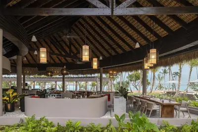 a restaurant with tables and chairs and lights at Zemi Miches Punta Cana All-Inclusive Resort, Curio by Hilton in Miches