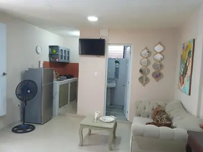 a living room with a white couch and a kitchen at Villa rozenuda in Boca Chica