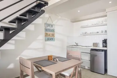 a kitchen with a wooden table and chairs and a sink at Kite Beach Penthouse in Cabarete