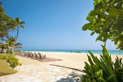 a beach with a row of chairs and the ocean at Kite Beach Penthouse in Cabarete