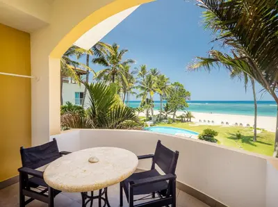 a table and chairs on a balcony with a view of the beach at Kite Beach Penthouse in Cabarete