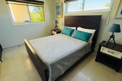 a bedroom with a large bed with blue pillows at Casa Linda Villa 920 - Sosua in Sosúa