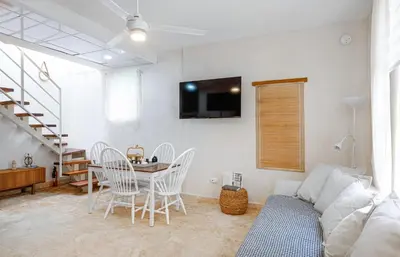 a living room with a table and chairs and a couch at Enriquillo 2-Bedroom Apt Casa Areito in Santo Domingo