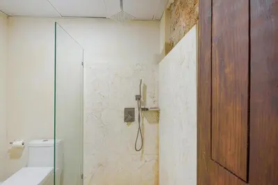 a bathroom with a shower with a toilet and a glass door at Enriquillo 2-Bedroom Apt Casa Areito in Santo Domingo