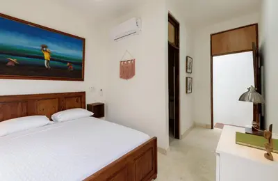 a bedroom with a bed and a painting on the wall at Guacanagarix 2-Bedroom Apt Casaareito in Santo Domingo