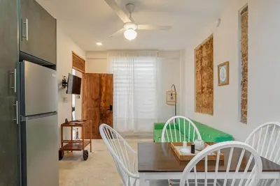 a kitchen with a table and chairs and a refrigerator at Guacanagarix 2-Bedroom Apt Casaareito in Santo Domingo