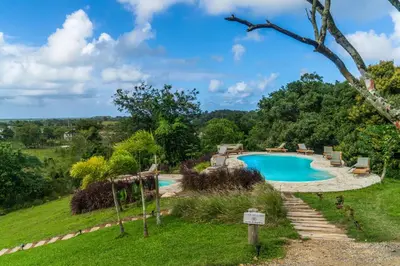 a swimming pool in a yard with a grassy field at Margarita Ecovillage in Miches