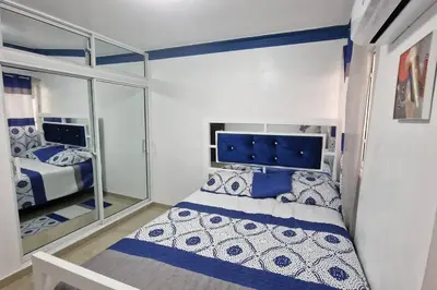 a small bedroom with a bed and a mirror at Lujosa y espaciosa Villa María. in Santiago de los Caballeros