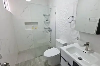 a bathroom with a shower and a toilet and a sink at Lujosa y espaciosa Villa María. in Santiago de los Caballeros