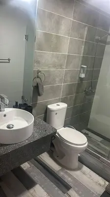 a bathroom with a white toilet and a sink at Acogedor Sweet Apartament in Santiago de los Caballeros