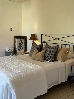 a bedroom with a large white bed with pillows at Cerca de Aeropuerto , bleseed house in Monte Adentro