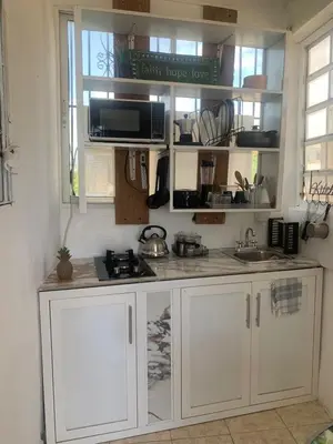 a kitchen with white cabinets and a sink at Cerca de Aeropuerto , bleseed house in Monte Adentro