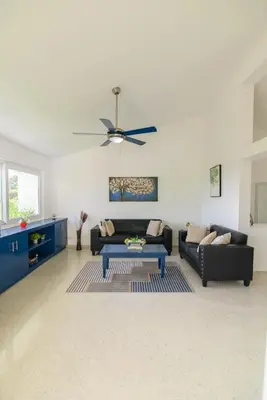 a living room with a couch and a table at Mango y Jobo - Relaxed Mountain & Sea Panoramic view - 10mins drive to beach and city in San Felipe de Puerto Plata