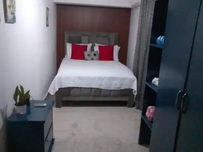 a bedroom with a bed with red pillows at Mango y Jobo - Relaxed Mountain & Sea Panoramic view - 10mins drive to beach and city in San Felipe de Puerto Plata