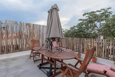a wooden table with an umbrella on a patio at 3 Studios at Casa Areito in Santo Domingo