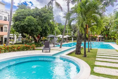 a swimming pool at a resort with a slide at Infiniti Blu, Sosua in Sosúa