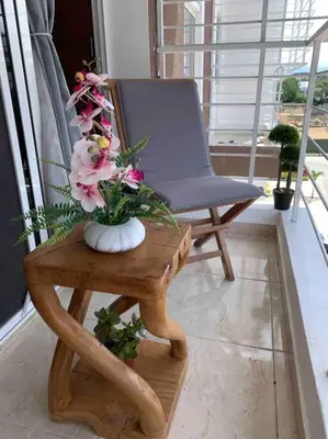 a vase of flowers on a table next to a chair at Nice and Breezy Apartment in Santiago de los Caballeros