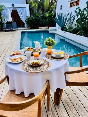 a table with food on it next to a swimming pool at Leeloo Boutique Hotel in Las Terrenas