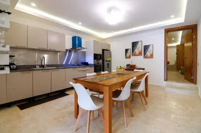 a kitchen with a wooden table and white chairs at Villa loren A3 in Las Terrenas